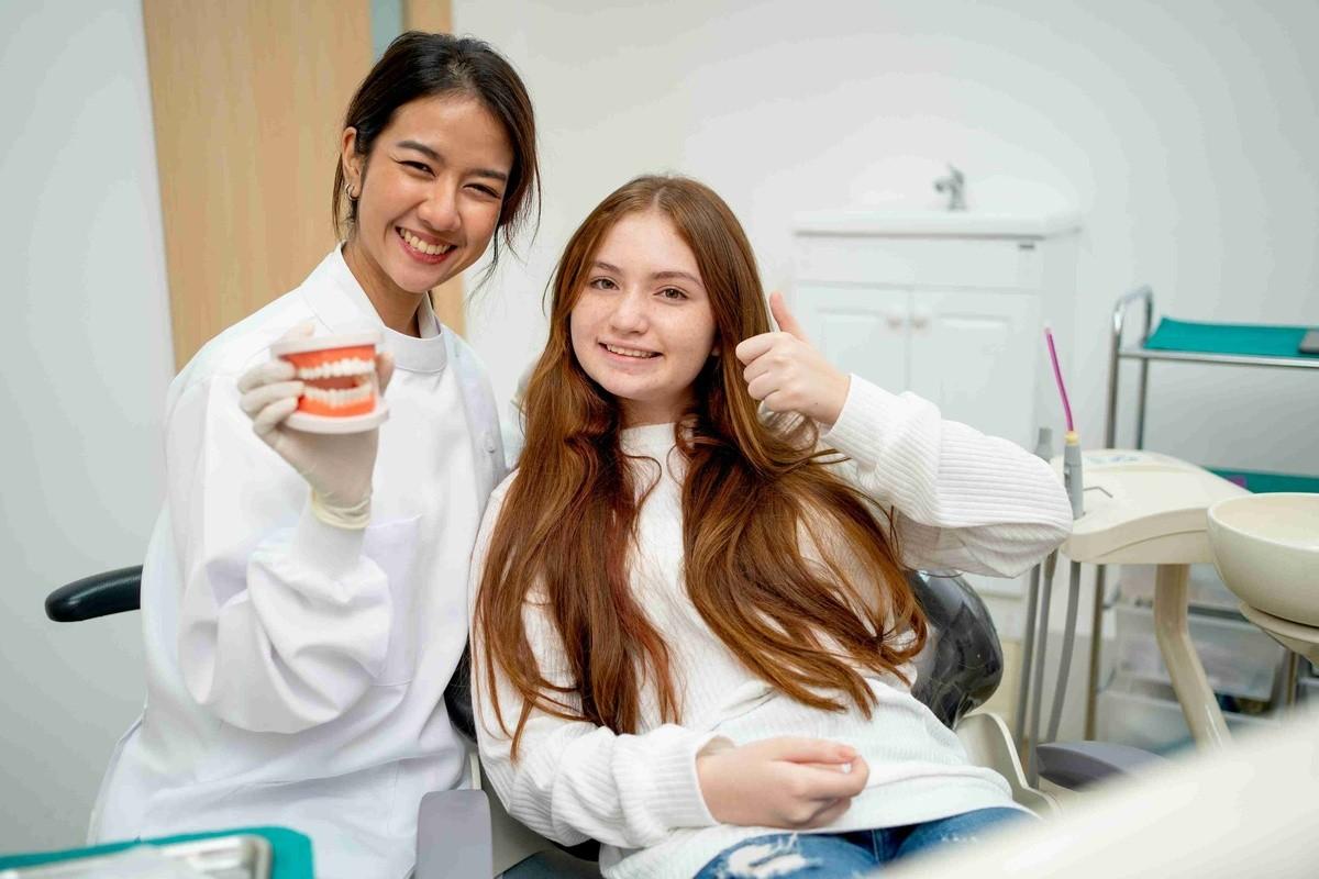 Orthodontist explaining braces treatment to a young patient during a consultation